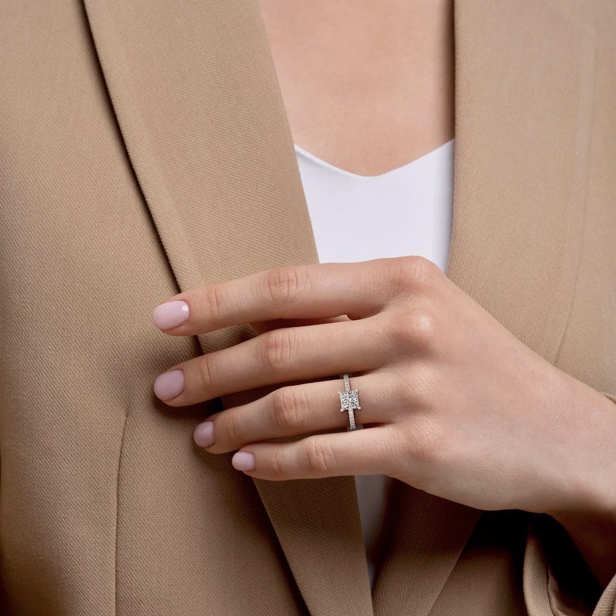 This is a 1.80 carat princess cut hidden halo lab-grown diamond engagement ring, framed with pavé shoulders, from Brilani.