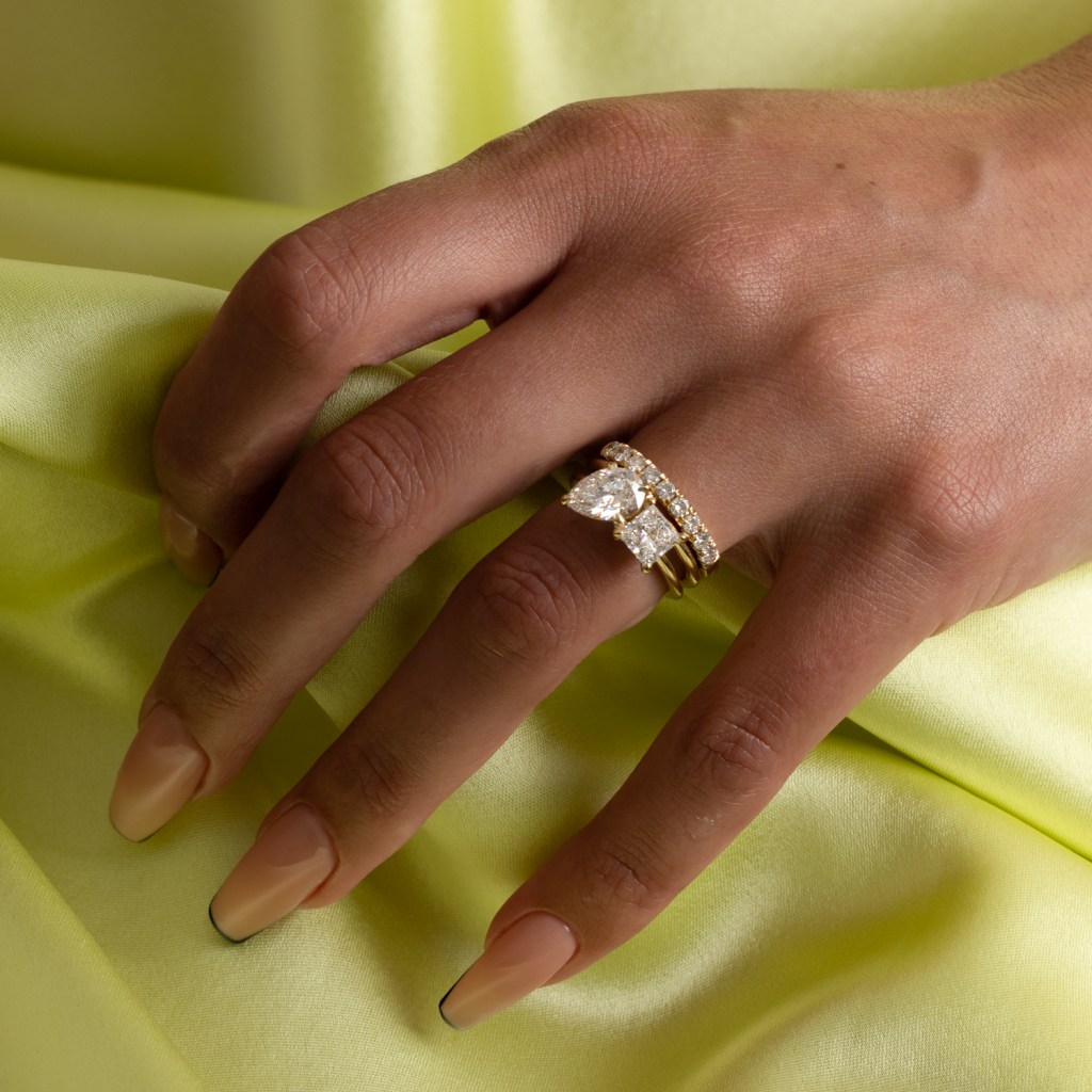 This is the Vivi Pear and Princess Engagement Ring in 14k yellow gold, set with a princess-cut diamond and a pear-cut diamond, from lab-grown diamond brand Eliette. Total carat weight approx 2.60ct.