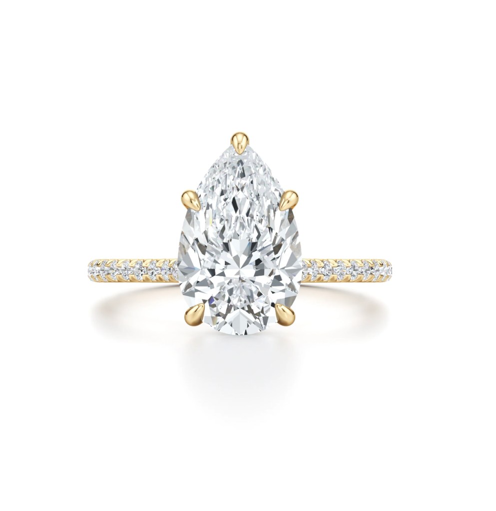 This is the Chelsea Solitaire Engagement Ring in 18k yellow gold, with a Pear Cut Center and Round Pavé, from lab-grown diamond brand Jean Dousset.